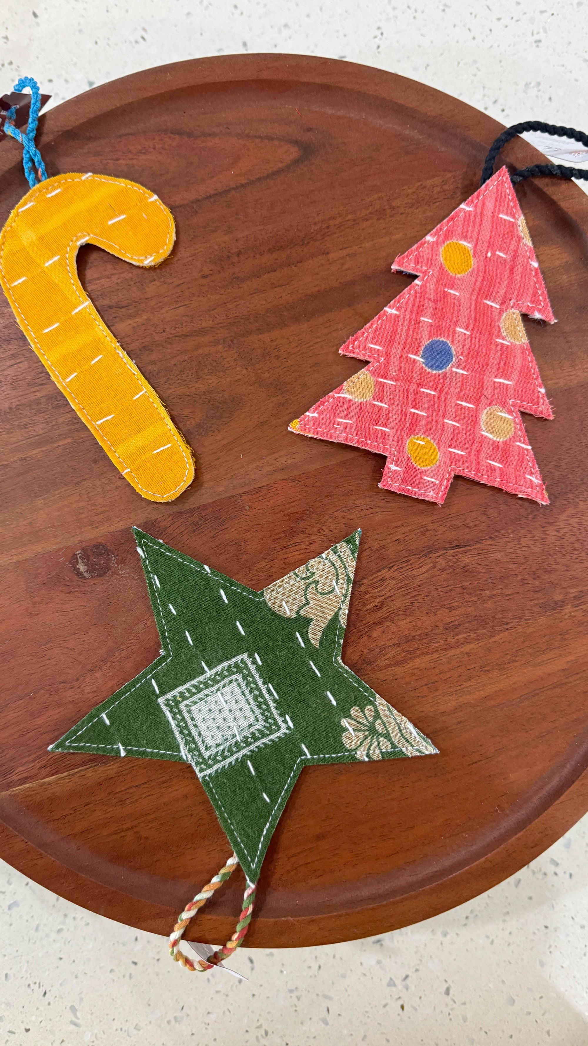 a wooden tray with three felt christmas trees on it