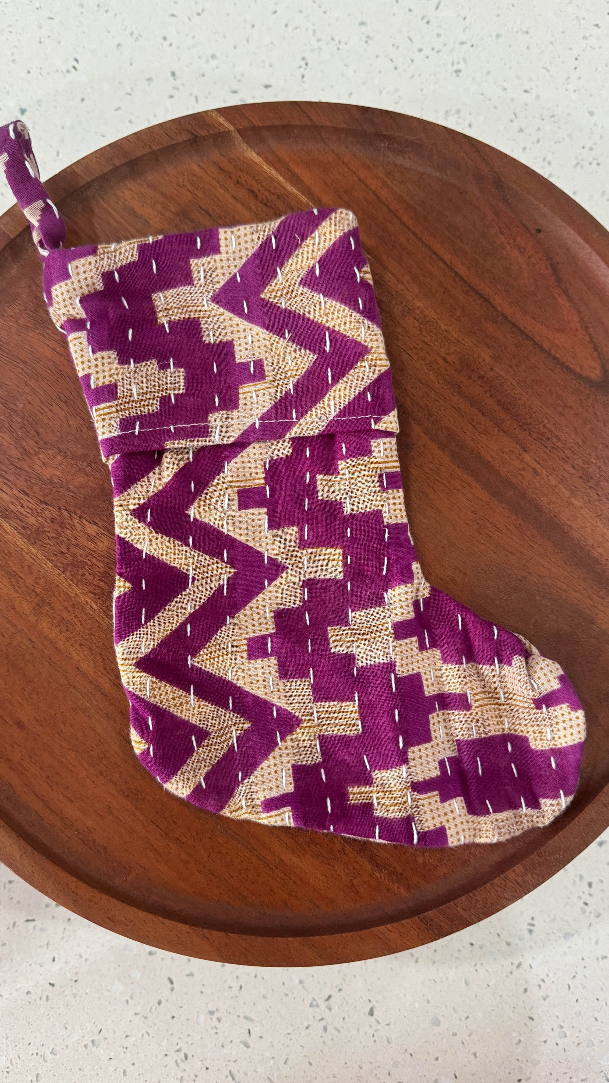 a purple and white stocking sitting on top of a wooden table