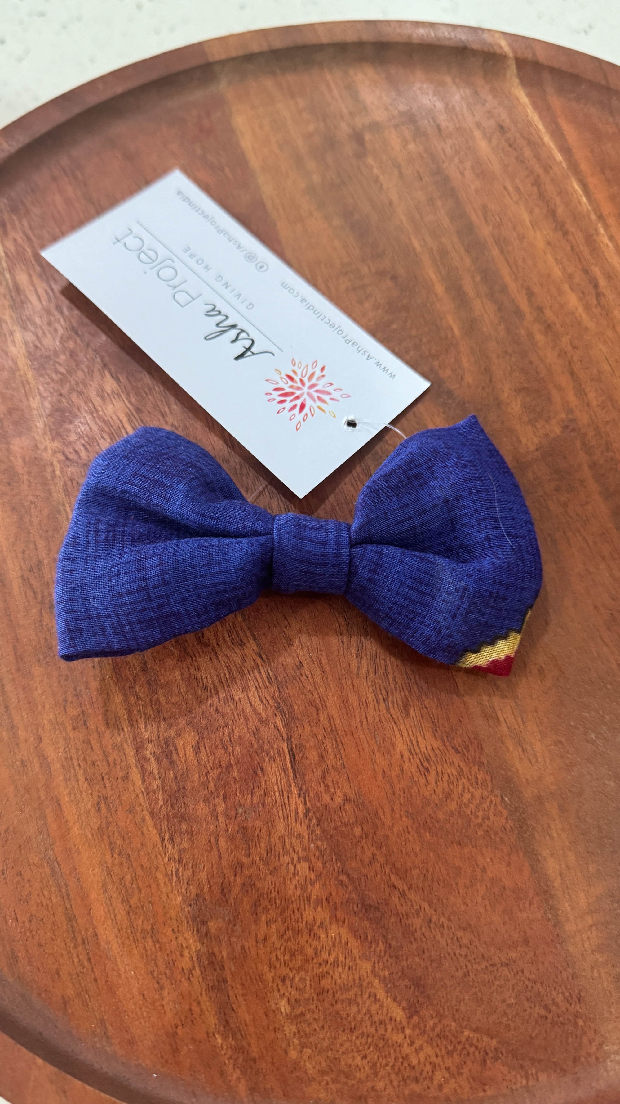 a blue bow tie sitting on top of a wooden table