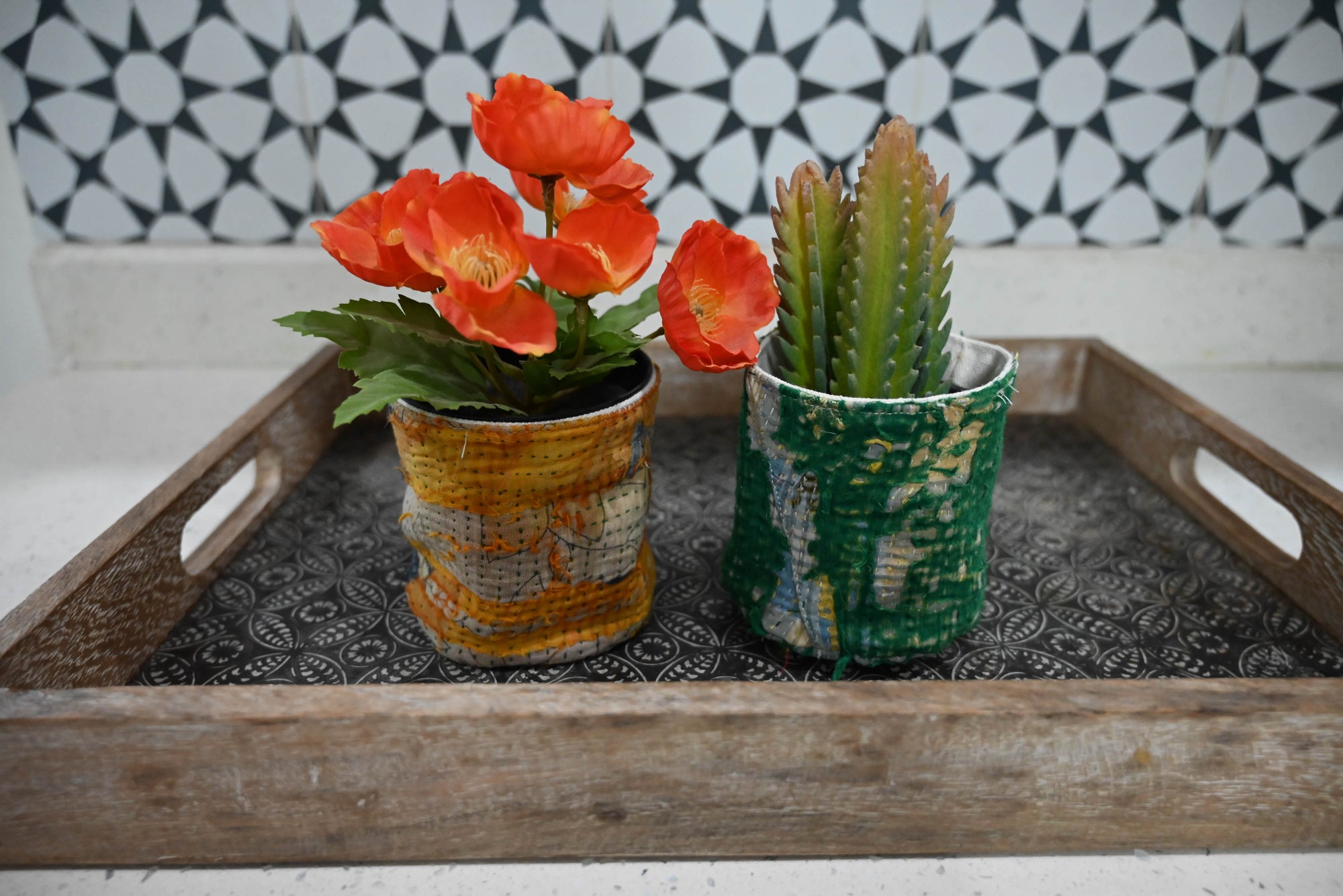 a tray with two pots of flowers on it