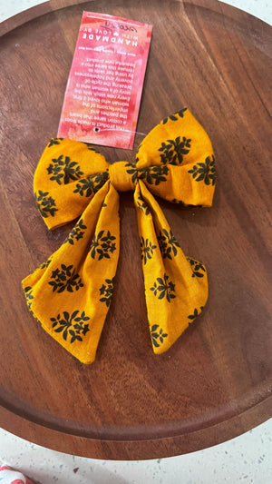 a wooden table topped with a yellow and black bow