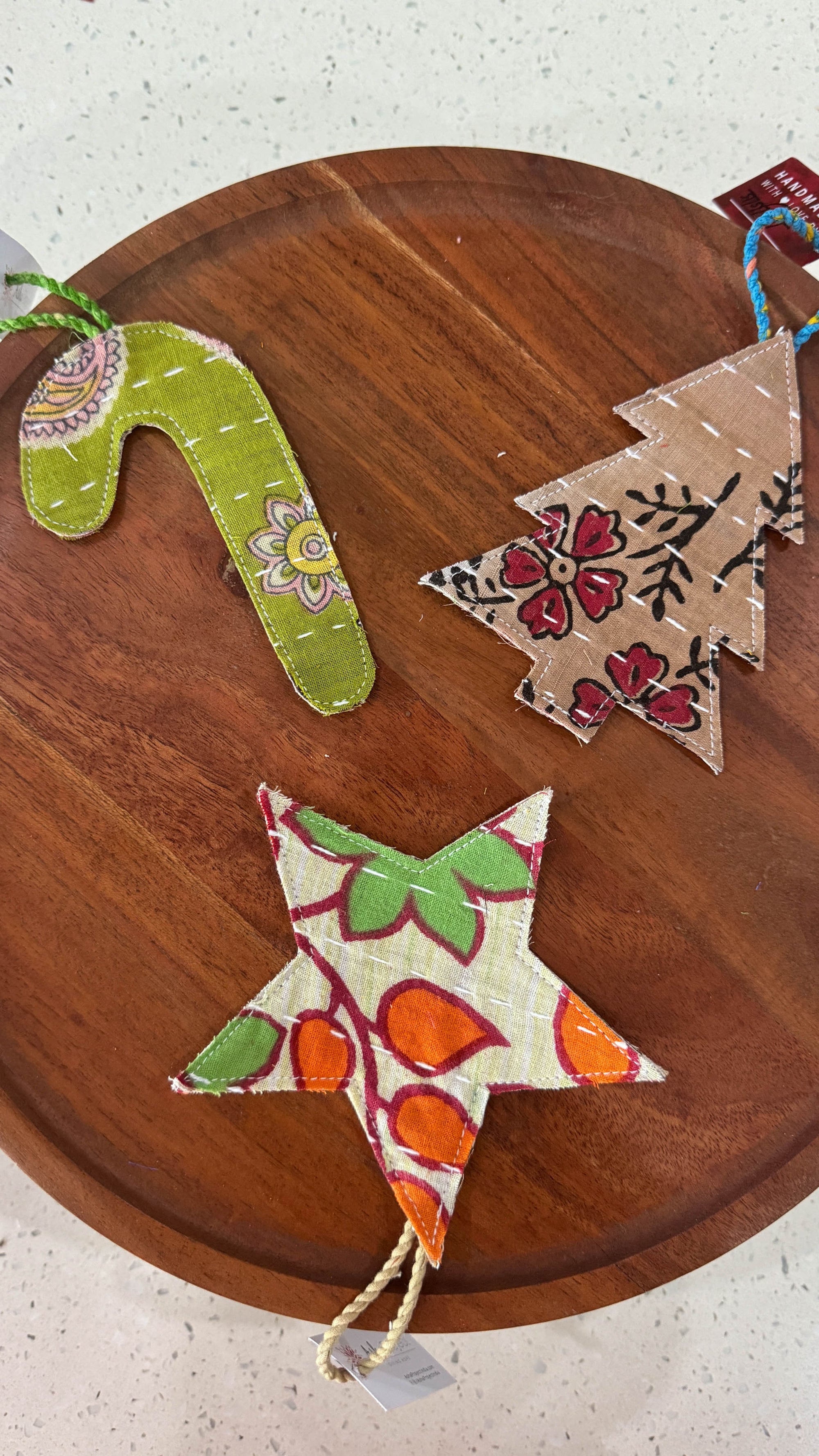 a wooden table topped with three christmas decorations