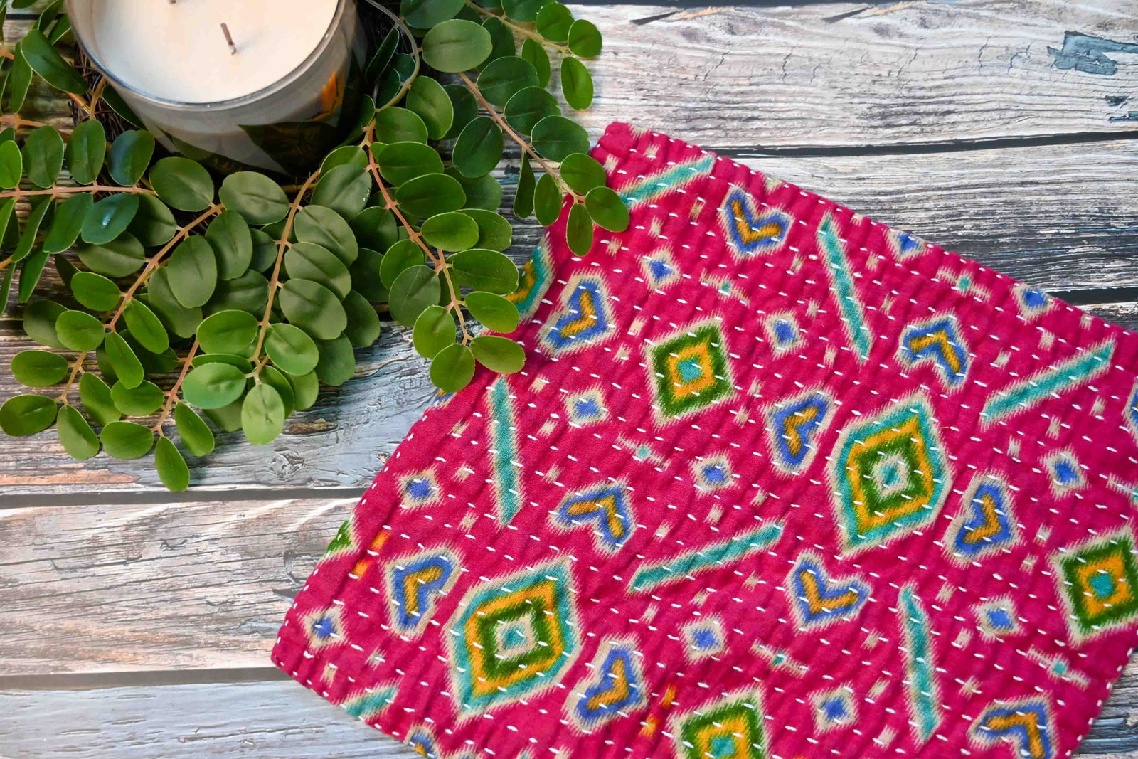 a table with a candle and some plants on it