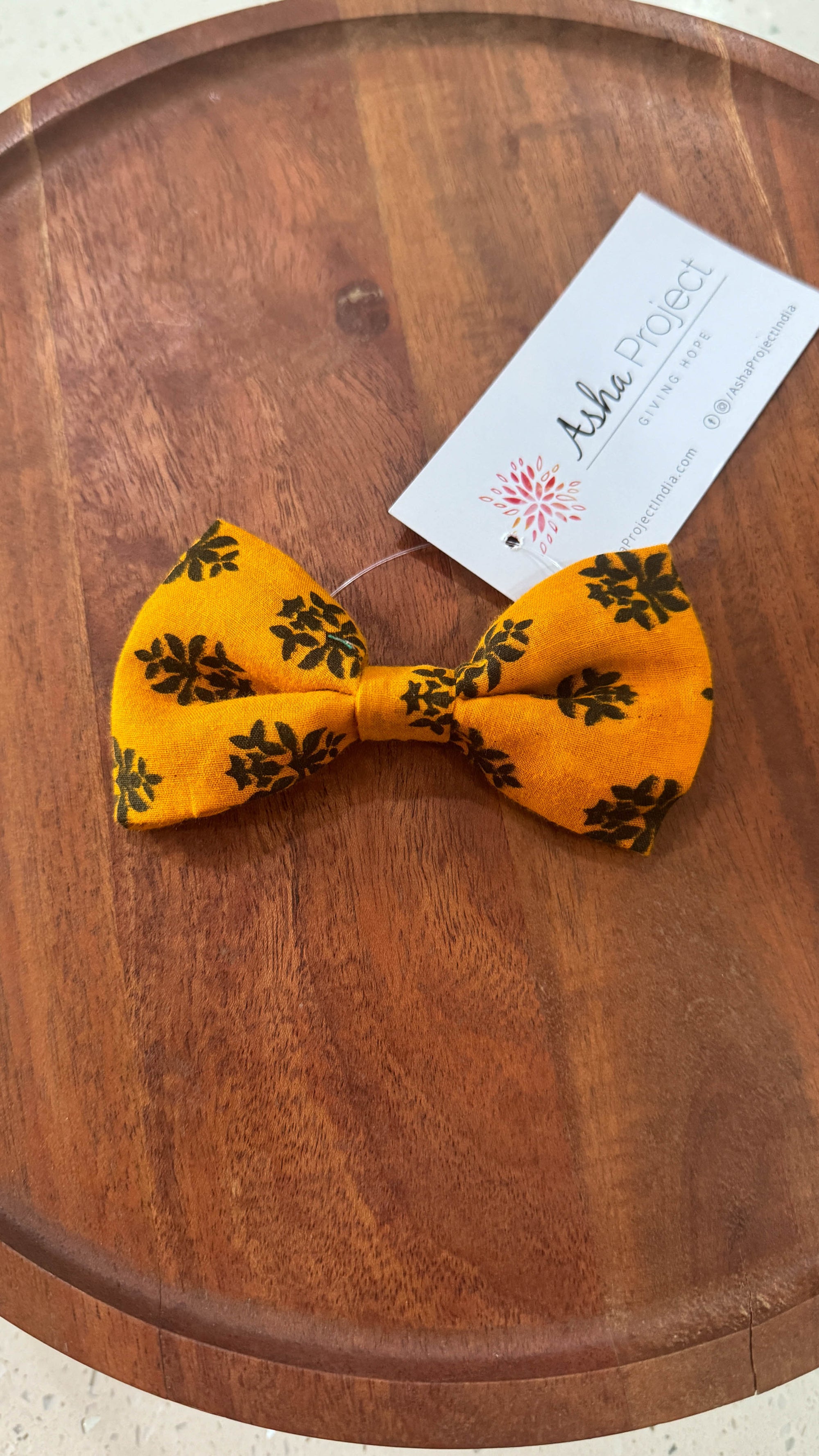 a yellow bow tie sitting on top of a wooden table