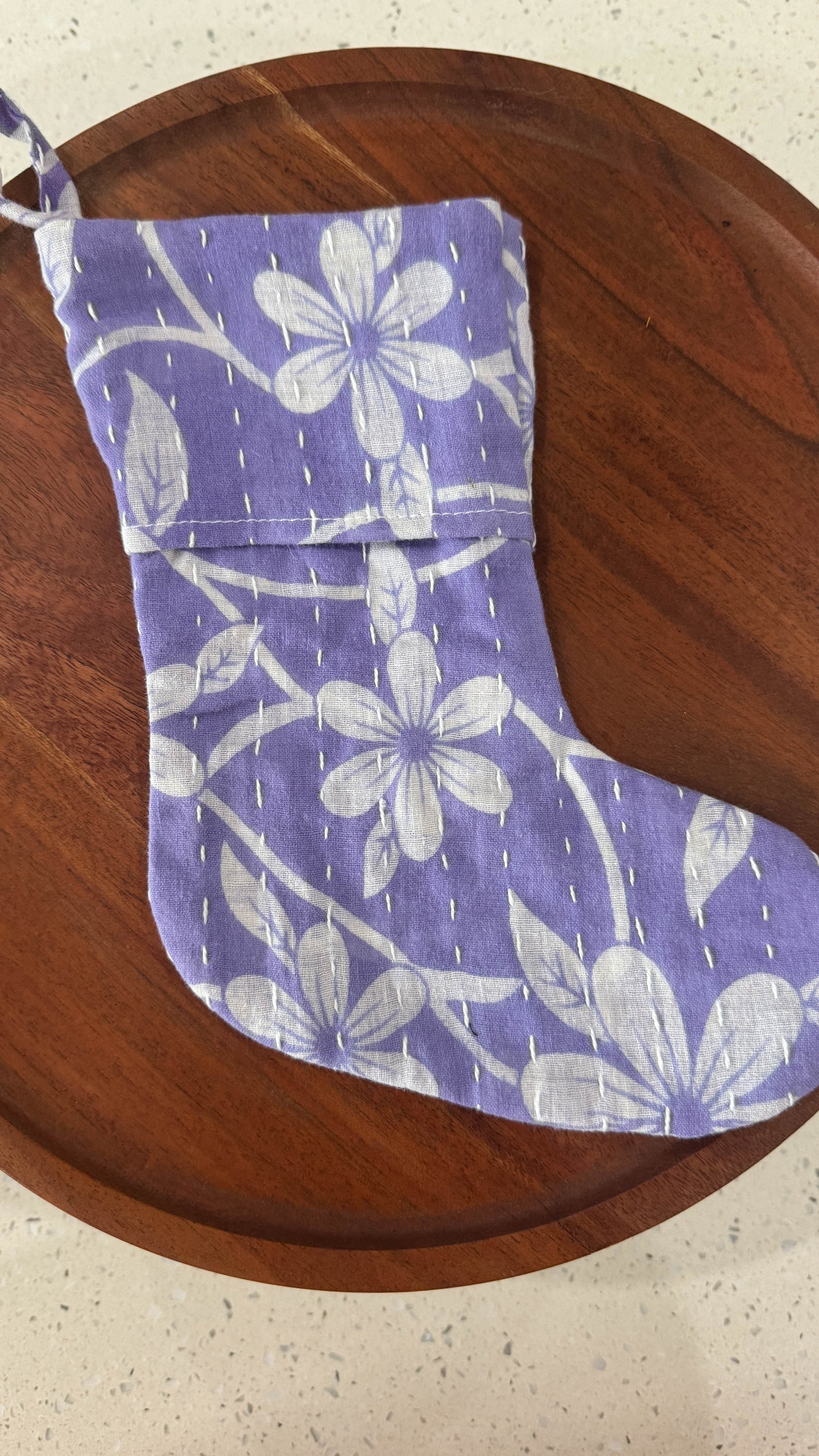 a purple and white stocking sitting on top of a wooden table