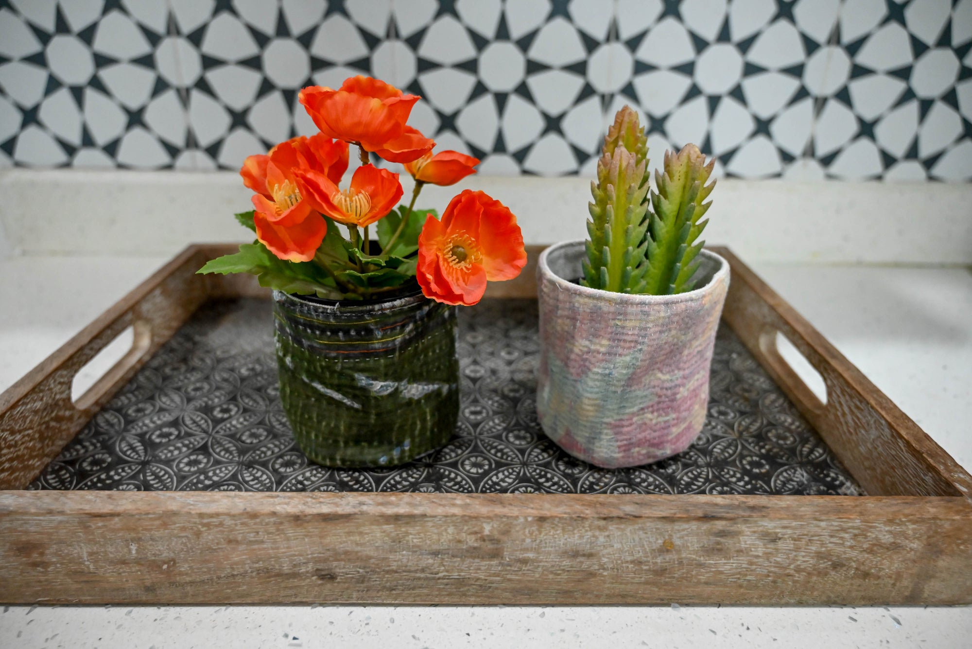 a tray with two vases of flowers on it