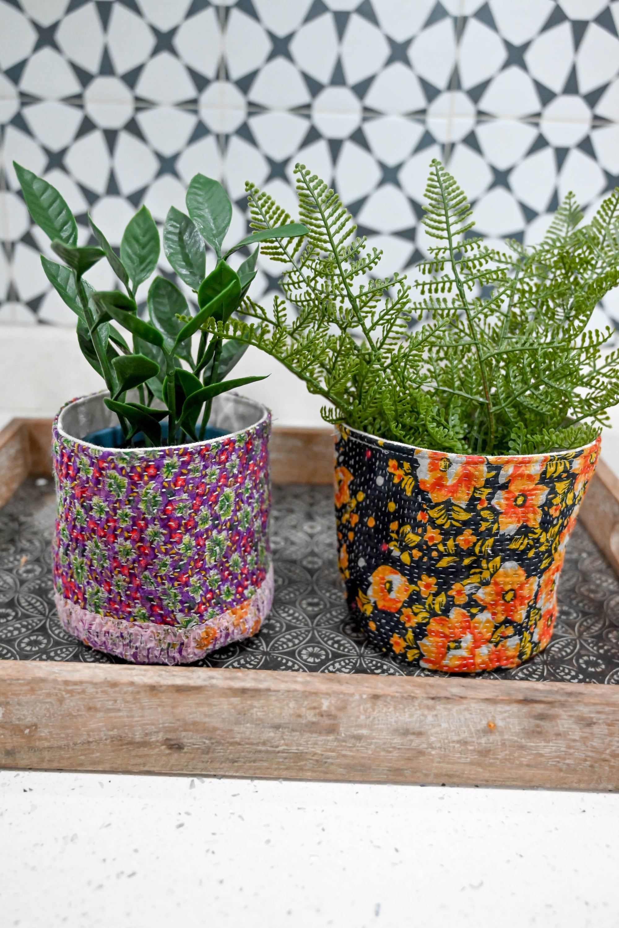 a couple of potted plants sitting on top of a wooden tray