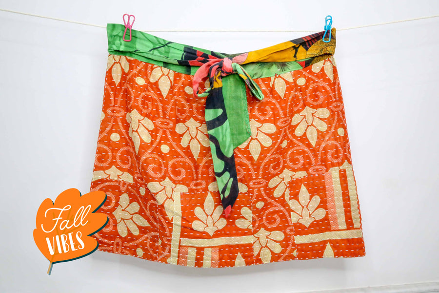 Handmade Kantha apron crafted from recycled sari fabric with colorful patchwork and traditional running stitches.
Vibrant boho kitchen apron made with upcycled cotton saris, pleated design, and a wide waistband that ties into a bow.