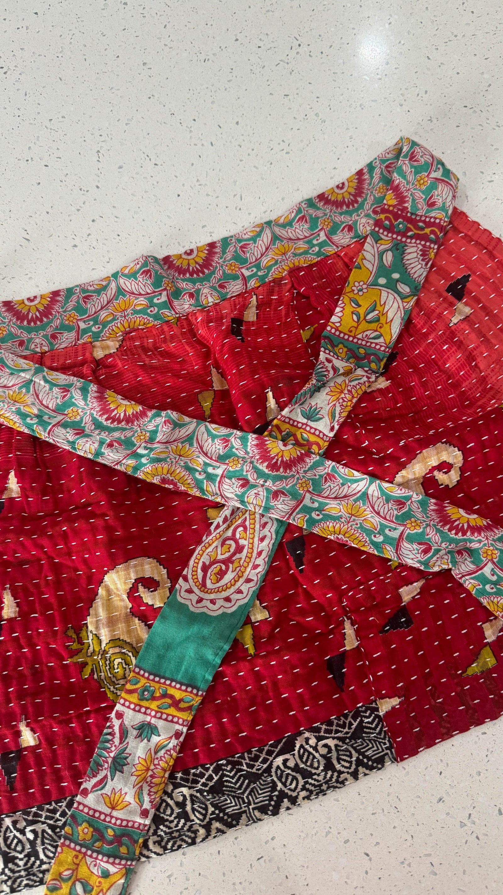 Handmade Kantha half apron with intricate stitching and vibrant fabric patterns, perfect for adding a touch of traditional style to your kitchen while cooking or crafting.