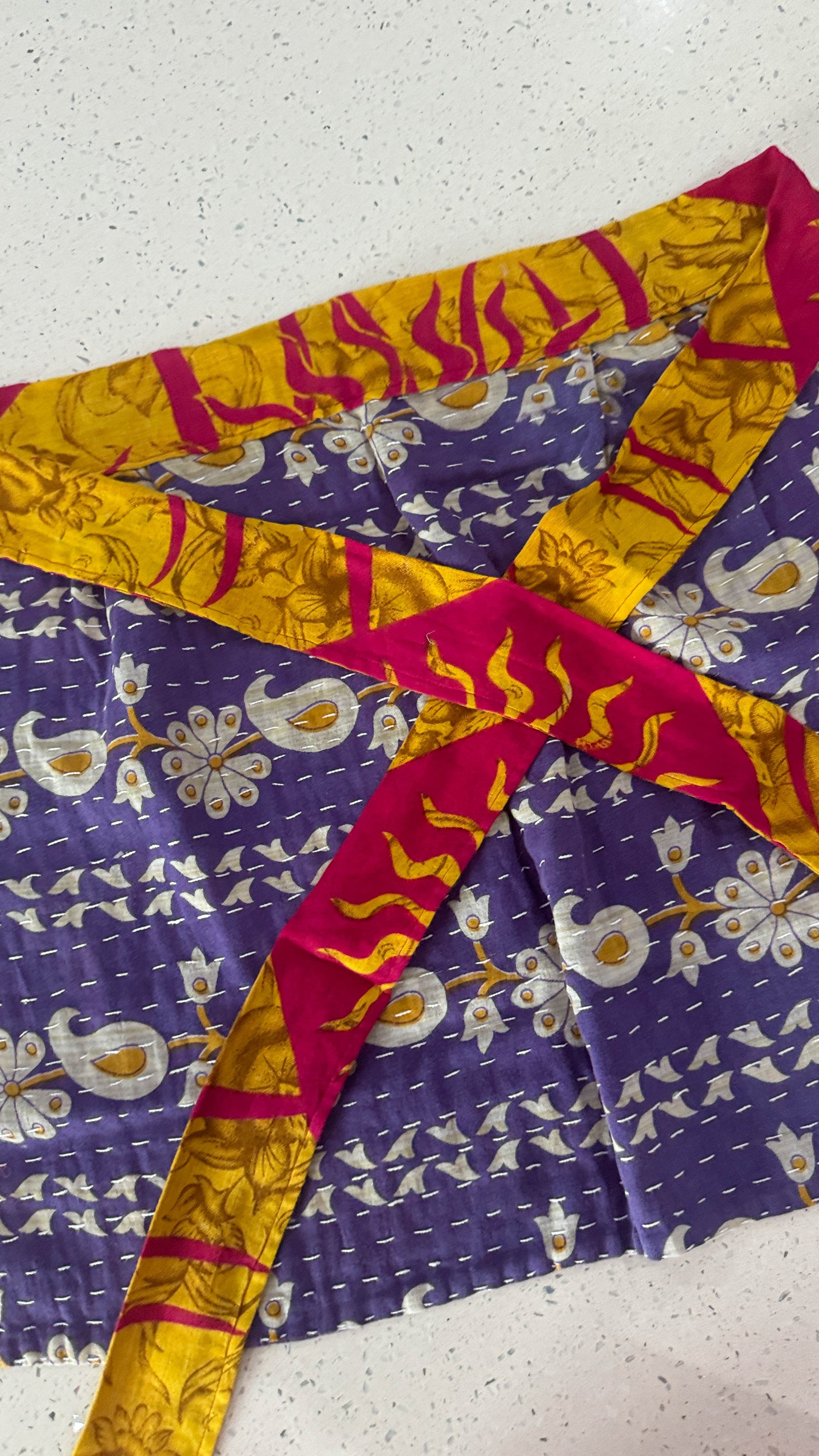 Handmade Kantha half apron with intricate stitching and vibrant fabric patterns, perfect for adding a touch of traditional style to your kitchen while cooking or crafting.