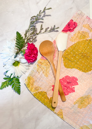 A vibrant, hand-stitched Kantha dish cloth featuring a colorful design. The cloth is made from soft, lightweight recycled saree fabric with intricate running stitches creating a textured pattern. The colors of fresh spring meadow add a playful and rustic touch to kitchen cleaning essentials.