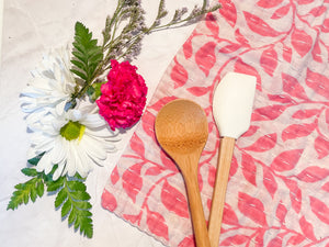 A vibrant, hand-stitched Kantha dish cloth featuring a colorful design. The cloth is made from soft, lightweight recycled saree fabric with intricate running stitches creating a textured pattern. The colors of fresh spring meadow add a playful and rustic touch to kitchen cleaning essentials.
