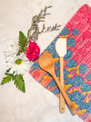 A vibrant, hand-stitched Kantha dish cloth featuring a colorful design. The cloth is made from soft, lightweight recycled saree fabric with intricate running stitches creating a textured pattern. The colors of fresh spring meadow add a playful and rustic touch to kitchen cleaning essentials.