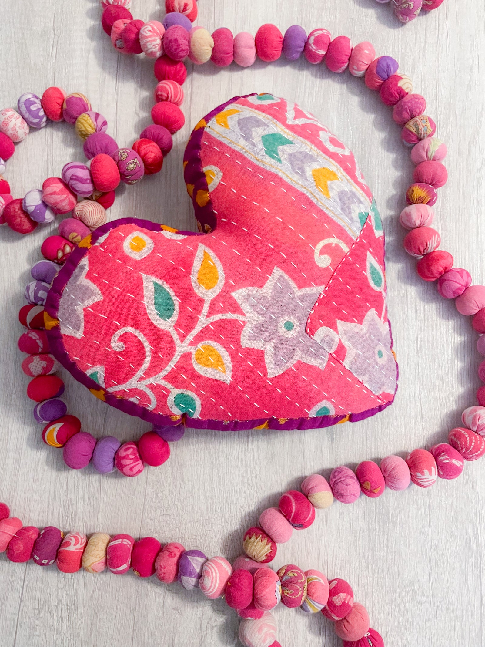 Handmade Kantha heart pillow with vibrant stitching and colorful saree patterns, perfect as a throw pillow for your bed or couch, adding a touch of traditional style and comfort to any room.