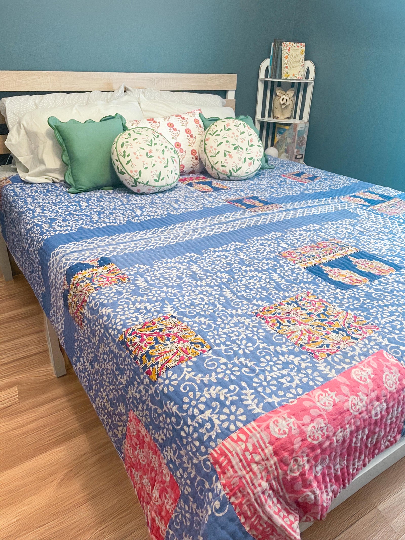 A beautiful Hope Quilt made from recycled sarees, featuring intricate Kantha stitching. This vibrant quilt, designed to fit a full/queen bed, showcases a patchwork of colorful fabric pieces, each carefully hand-stitched together. The delicate Kantha stitching adds texture and depth, creating a warm, sustainable, and artistic piece for your bed.