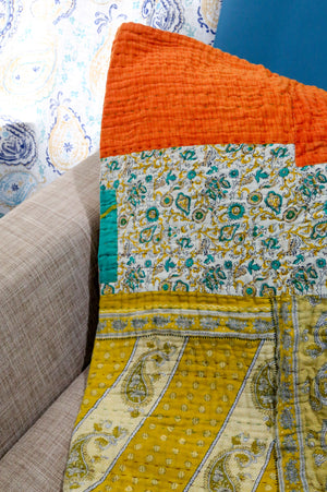 A beautiful Hope Quilt made from recycled sarees, featuring intricate Kantha stitching. This vibrant quilt, designed to fit a full/queen bed, showcases a patchwork of colorful fabric pieces, each carefully hand-stitched together. The delicate Kantha stitching adds texture and depth, creating a warm, sustainable, and artistic piece for your bed.