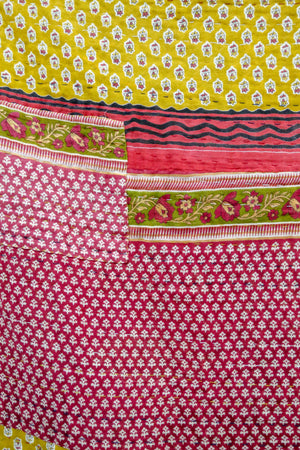 A beautiful Hope Quilt made from recycled sarees, featuring intricate Kantha stitching. This vibrant quilt, designed to fit a full/queen bed, showcases a patchwork of colorful fabric pieces, each carefully hand-stitched together. The delicate Kantha stitching adds texture and depth, creating a warm, sustainable, and artistic piece for your bed.