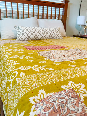 A beautiful Hope Quilt made from recycled sarees, featuring intricate Kantha stitching. This vibrant quilt, designed to fit a full/queen bed, showcases a patchwork of colorful fabric pieces, each carefully hand-stitched together. The delicate Kantha stitching adds texture and depth, creating a warm, sustainable, and artistic piece for your bed.