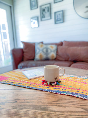 Reversible kantha table runner featuring two vibrant saree  patterns. The runner is stitched with delicate kantha embroidery, adding texture and charm to both sides.