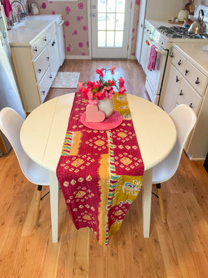 Reversible kantha table runner featuring two vibrant saree  patterns. The runner is stitched with delicate kantha embroidery, adding texture and charm to both sides.
