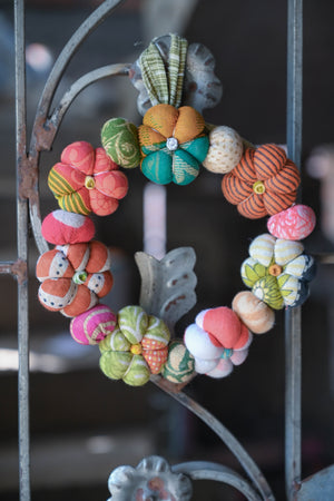 Mini Saree pumpkin wreath made with colorful, hand-stitched fabric pumpkins and vibrant saree scraps, perfect for adding a festive, eco-friendly touch to fall or Halloween decor