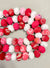 Handmade Valentine’s bead garland featuring a mix of red, pink, and white beads, crafted from recycled saree scraps, perfect for adding a festive and eco-friendly touch to your Valentine’s Day decor.