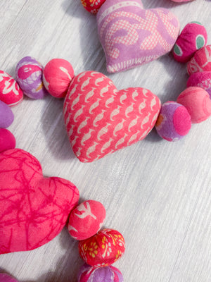 Saree heart garland made from colorful, recycled saree fabric hearts, strung together with Saree beads to create a vibrant and eco-friendly decoration for home or special occasions.