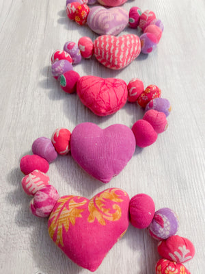 Saree heart garland made from colorful, recycled saree fabric hearts, strung together with Saree beads to create a vibrant and eco-friendly decoration for home or special occasions.