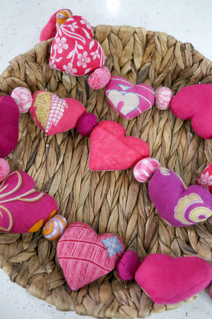 Saree heart garland made from colorful, recycled saree fabric hearts, strung together with Saree beads to create a vibrant and eco-friendly decoration for home or special occasions.