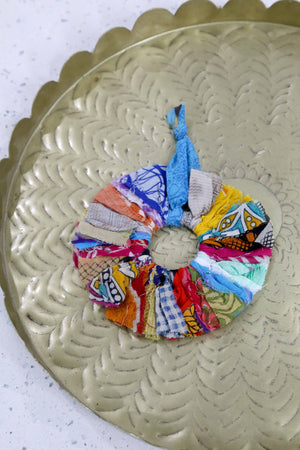 Vibrant Saree Sunburst Ornament, made from colorful saree scraps hand-tied to a ring, creating a bright and beautiful decorative piece perfect for adding a festive touch to your Christmas tree