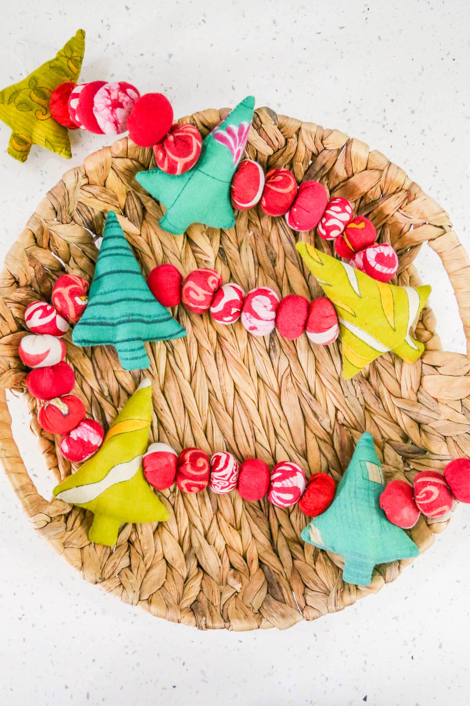 Saree Christmas tree garland with recycled green saree fabric trees and red saree beads strung together, creating a festive and colorful decoration for holiday home decor.