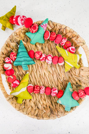 Saree Christmas tree garland with recycled green saree fabric trees and red saree beads strung together, creating a festive and colorful decoration for holiday home decor.