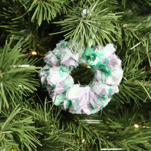 Small saree wreath ornament made from colorful hand tied saree fabric scraps, perfect for adding a vibrant and eco-friendly touch to holiday or home decor.
