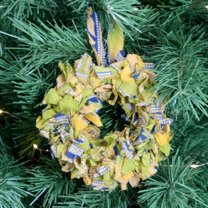 Small saree wreath ornament made from colorful hand tied saree fabric scraps, perfect for adding a vibrant and eco-friendly touch to holiday or home decor.