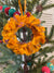 Small saree wreath ornament made from colorful hand tied saree fabric scraps, perfect for adding a vibrant and eco-friendly touch to holiday or home decor.