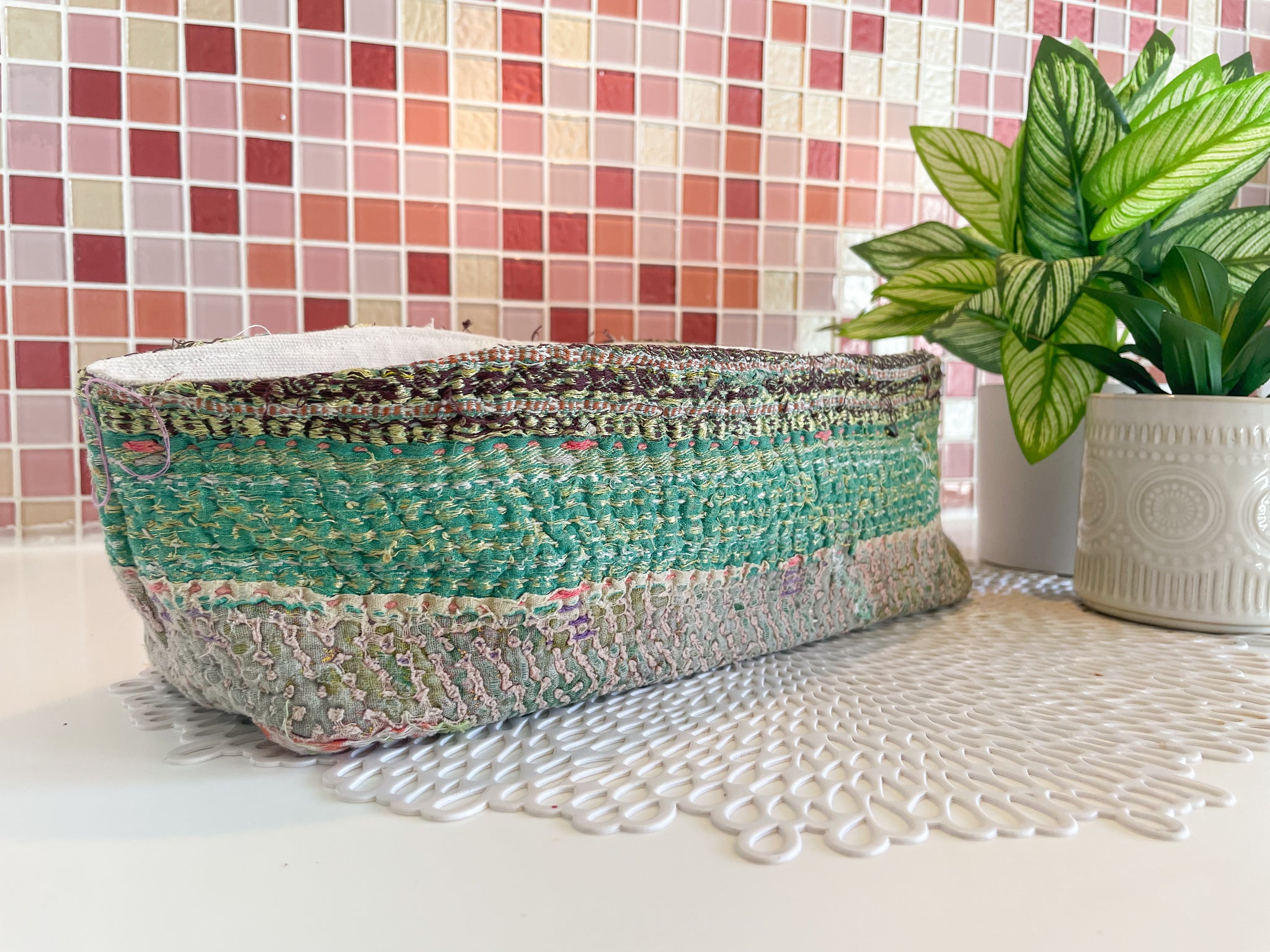 Vintage Kantha bread basket, handcrafted from eco-friendly fabric with vibrant, colorful stitching. The intricate Kantha embroidery features a mix of bold patterns and rich hues, making this basket both a functional and decorative piece. Perfect for serving bread, rolls, or storing small items, it adds a touch of rustic charm and handmade elegance to any kitchen or dining room