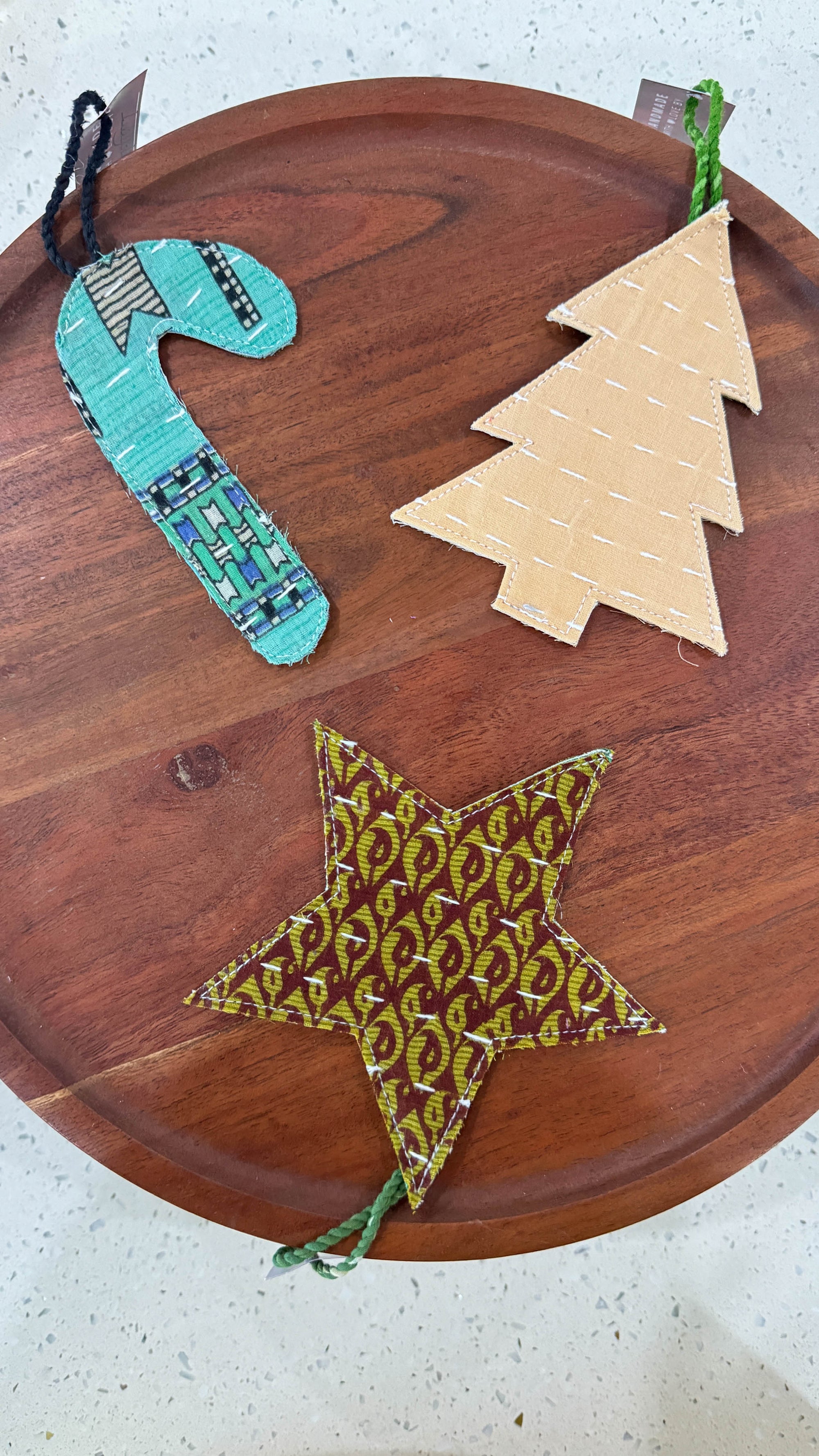 a wooden platter topped with paper cutouts of christmas trees