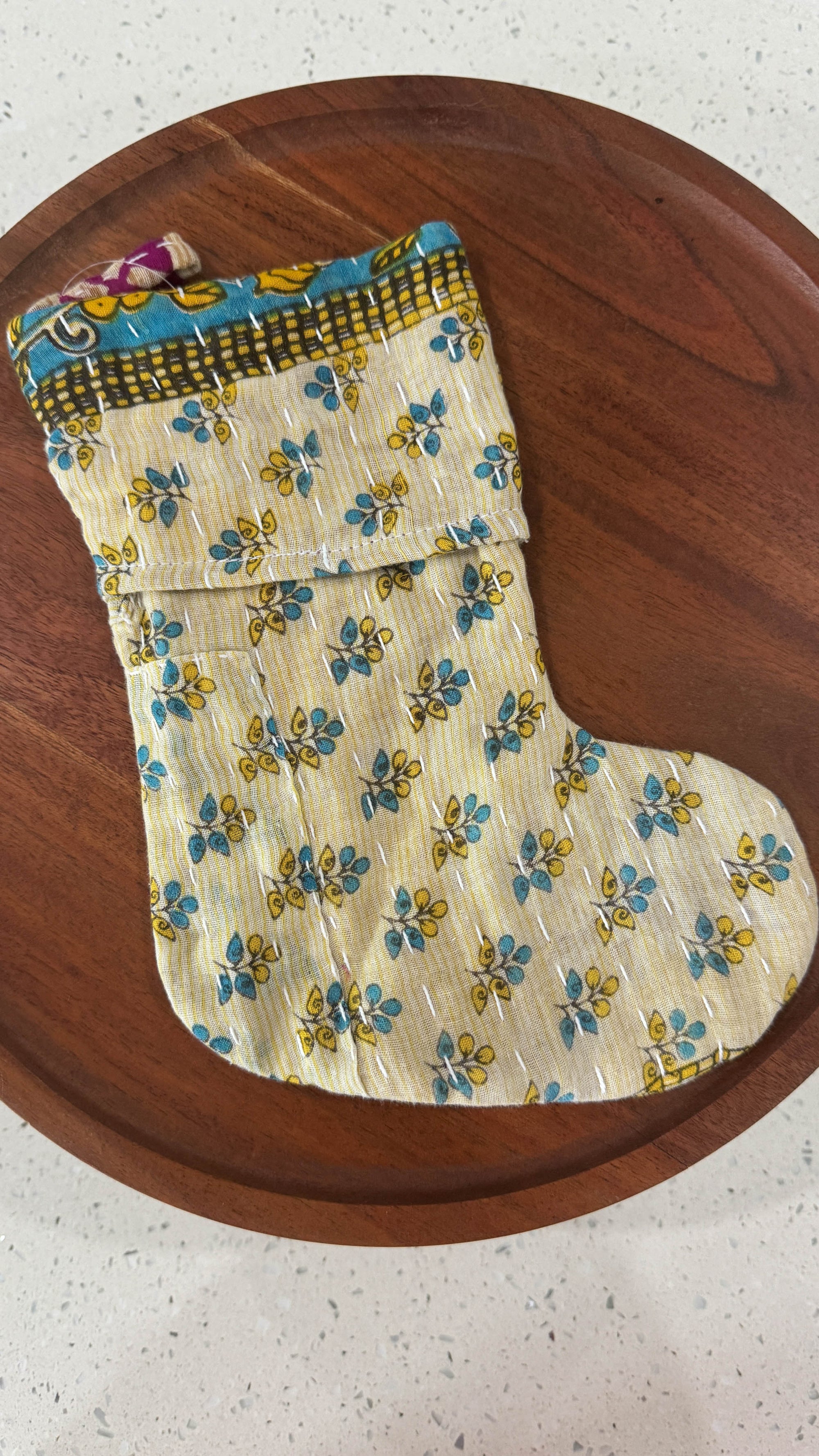 an oven mitt on a wooden plate on a table