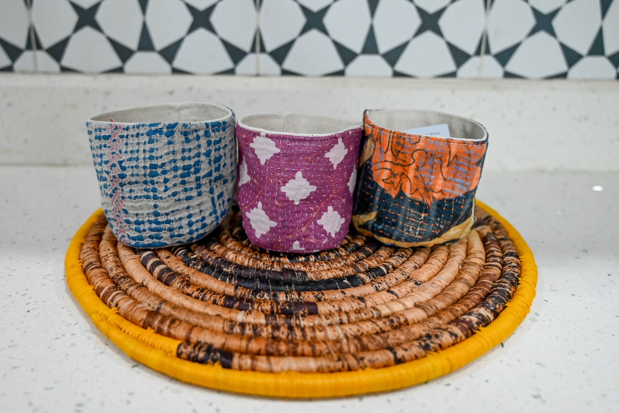 three cups sitting on top of a woven mat