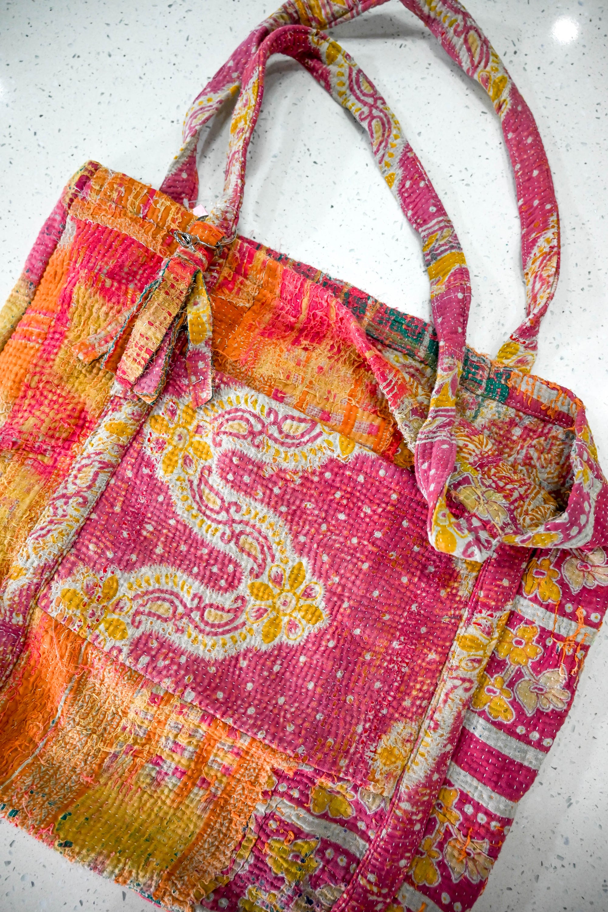 a pink and orange purse sitting on top of a counter