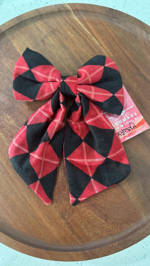 a red and black bow tie sitting on top of a wooden table