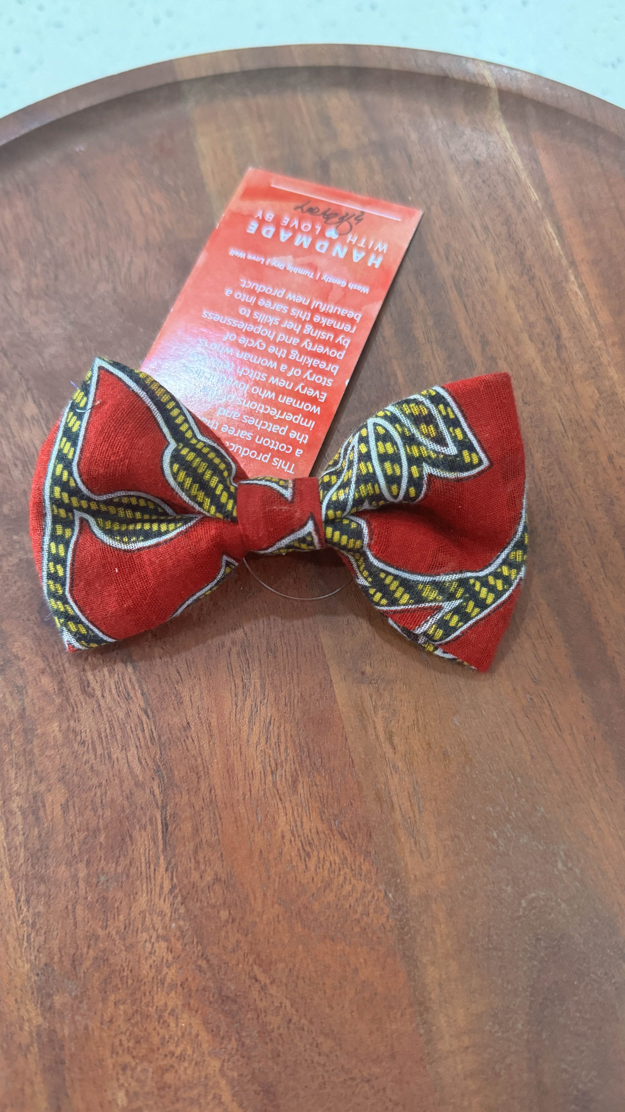 a red bow tie sitting on top of a wooden table