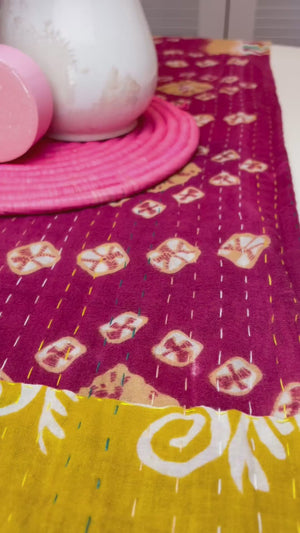 Reversible kantha table runner featuring two vibrant saree  patterns. The runner is stitched with delicate kantha embroidery, adding texture and charm to both sides.