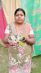 Kantha Whale A soft, handmade stuffed whale toy made from colorful kantha fabric. The whale features colorful saree patterns in vibrant shades of red, blue, yellow, and green, with a rounded body, a curved tail, and a friendly face. The textured fabric adds a unique, artisanal touch to the toy, making it both a decorative and cuddly piece.