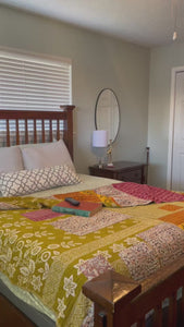A beautiful Hope Quilt made from recycled sarees, featuring intricate Kantha stitching. This vibrant quilt, designed to fit a full/queen bed, showcases a patchwork of colorful fabric pieces, each carefully hand-stitched together. The delicate Kantha stitching adds texture and depth, creating a warm, sustainable, and artistic piece for your bed.