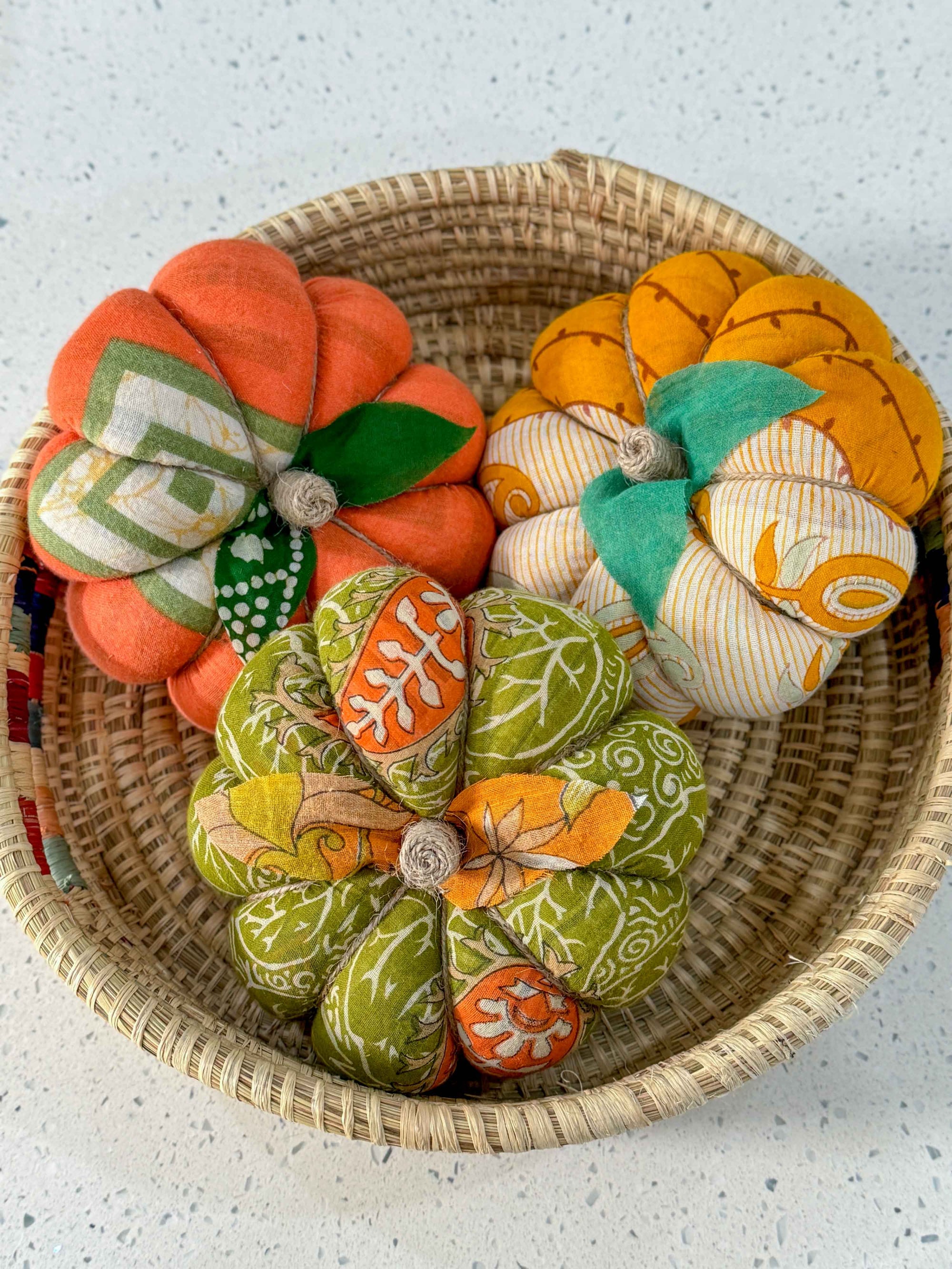 a basket filled with fabric pumpkins on top of a table