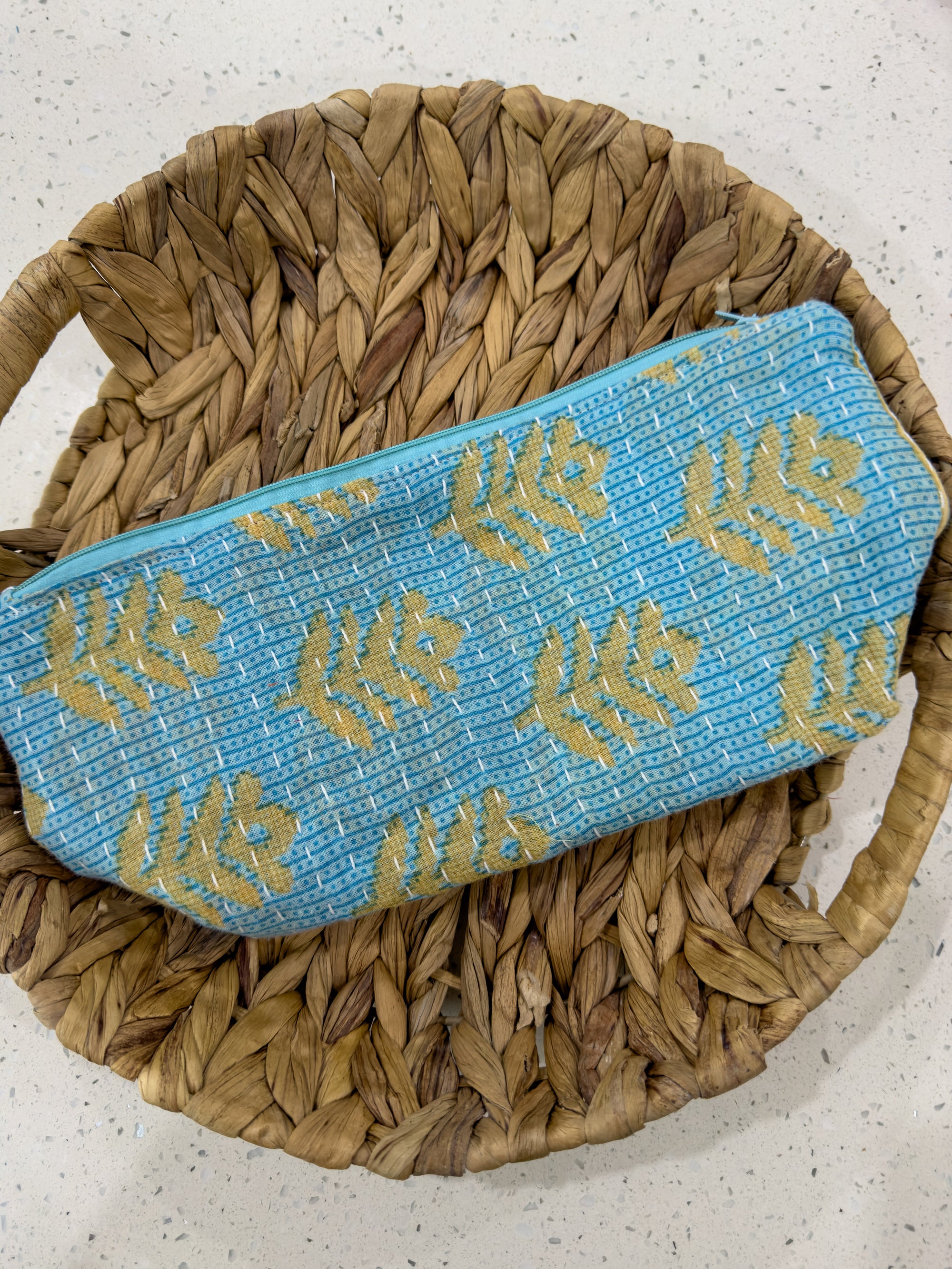 a blue and yellow bag sitting on top of a woven basket