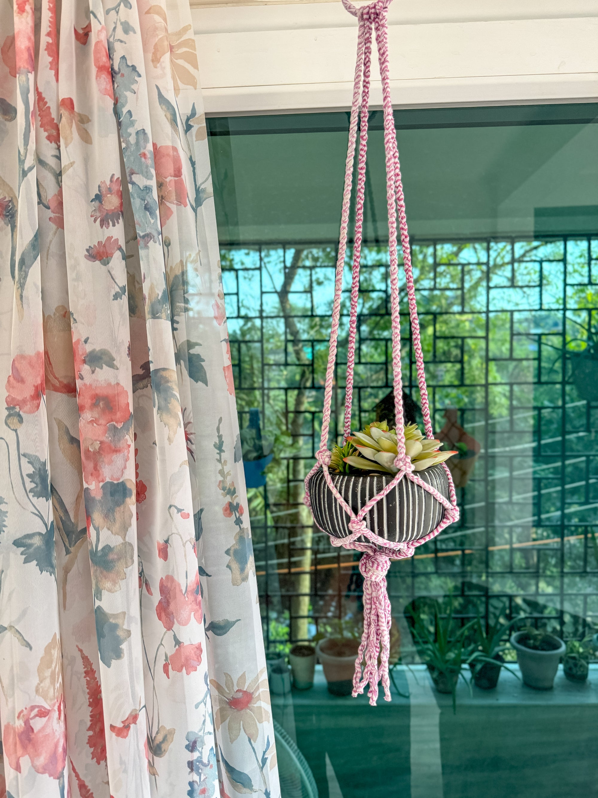 a bird cage hanging from a window next to a curtain