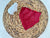 a red piece of cloth sitting on top of a woven basket