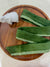 a wooden plate topped with green ribbons and a bottle of milk